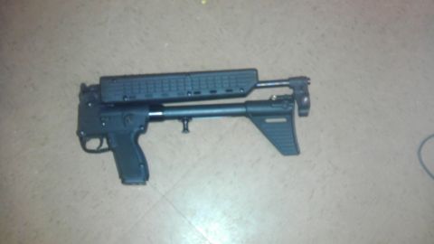 2000 Mercury Grand Marquis - A black firearm with a telescoping stock is shown on a tiled floor.