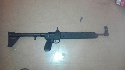 2000 Mercury Grand Marquis - A black semi-automatic rifle is displayed horizontally on a tiled surface.