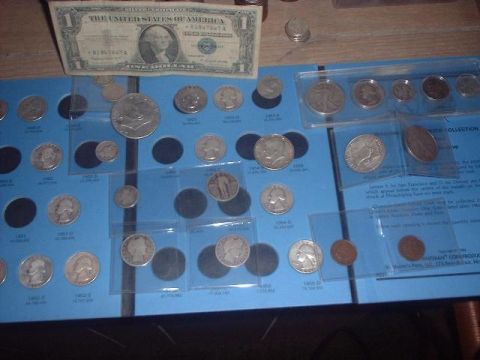 1993 Ford Bronco - A collection of various coins and a US dollar bill are displayed on a blue board with labels.