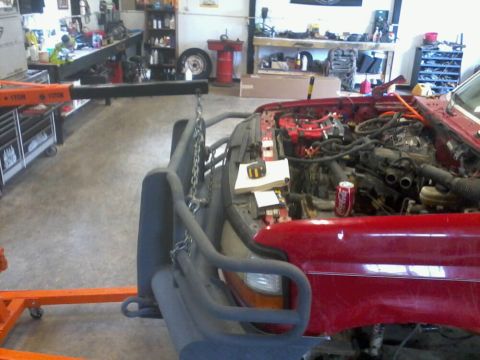 1995 Ford F-150 - Engine hoist attached to a 1995 Ford F-150 in a workshop. The hood is open, revealing the engine.