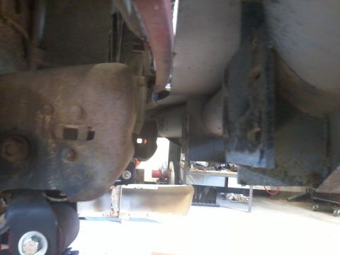 1995 Ford F-150 - Close-up of heavily rusted undercarriage components, possibly during a repair or inspection.