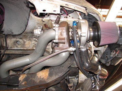1992 Ford Taurus - Close-up of a custom turbocharger installation in a vehicle's engine bay.