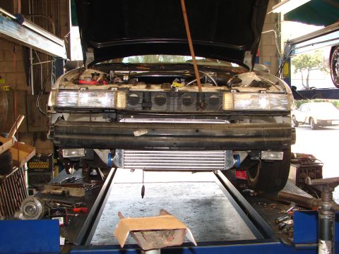 1992 Ford Taurus - Front view of a car on a lift with the hood open, revealing an aftermarket intercooler installed.