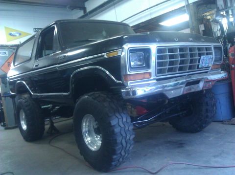 1979 Ford Bronco - This lifted Ford Bronco is shown in a garage with its front end visible.