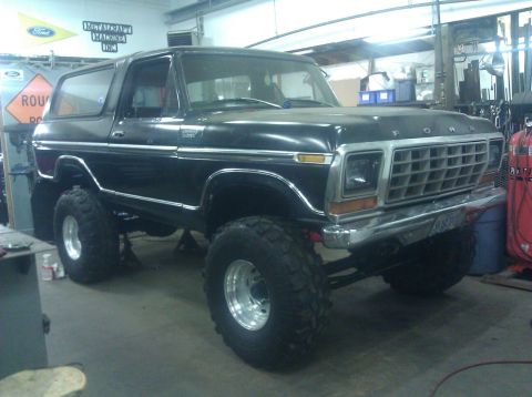 1979 Ford Bronco - This lifted black 1979 Ford Bronco features a prominent chrome grille and oversized off-road tires.