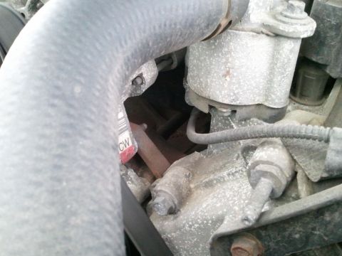 1999 Ford Crown Victoria - Close-up view of engine parts, including a hose and a tag with text.