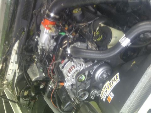 2000 Ford Crown Victoria - Close-up view of a vehicle's engine compartment, showing various mechanical components and a sticker.