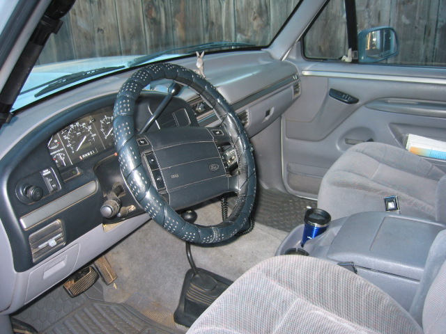Interior shot of a truck's dashboard and passenger seat, showing the steering wheel, gauges, and center console