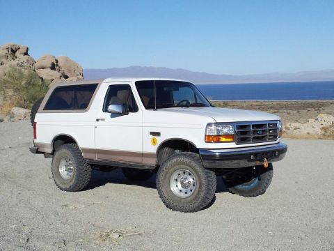 1996 Ford Bronco - This 1996 Ford Bronco is shown in a desert landscape with a lake and mountains visible.