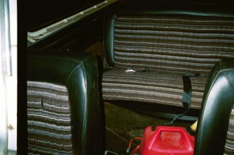 1979 Ford Bronco - The striped fabric of the rear seat is visible, along with a red gas can on the floor.