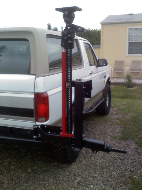 1996 Ford Bronco - A Hi-Lift Jack is mounted to the rear bumper of a white Ford Bronco.