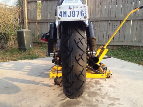 1995 Ford Bronco - Rear view of a motorcycle on a yellow jack, with a Texas license plate visible.