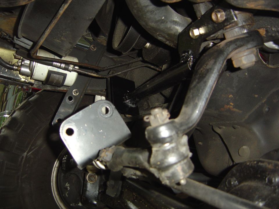 Underside view of vehicle steering linkage and suspension parts, including tie rods and sway bar