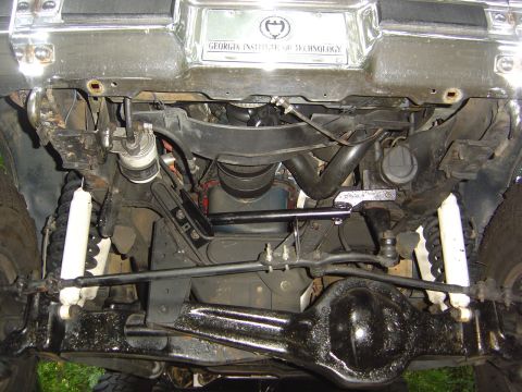 1986 Ford Bronco - The underside of a vehicle reveals its suspension and steering mechanisms, with a plate from Georgia Institute of Technology visible above.