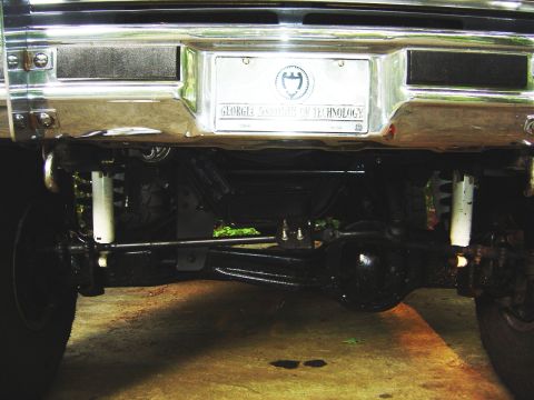 1986 Ford Bronco - Close-up view of the rear axle and suspension components, a license plate frame from Georgia Institute of Technology.