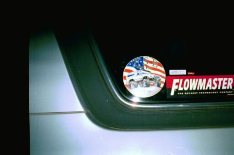 1979 Ford Bronco - Rear window features a Flowmaster sticker and a circular decal depicting a lifted truck against an American flag background.