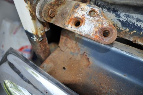1986 Ford Bronco - Close-up of rusted metal components and a chrome bumper, with a watermark for SuperMotors.net visible.