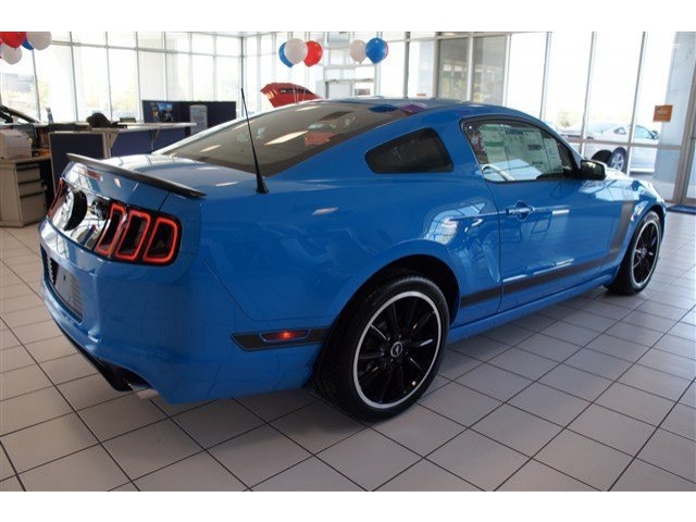 Grabber Blue Mustang Boss 302 coupe rear three-quarter view in dealership showroom