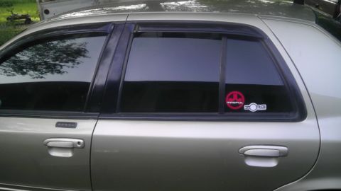 2000 Mercury Grand Marquis - Side profile of a gold sedan showing door handle, keypad entry, and window stickers.