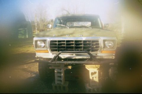 1979 Ford Bronco - This Ford Bronco is elevated on concrete blocks, showing its front grille and bumper.