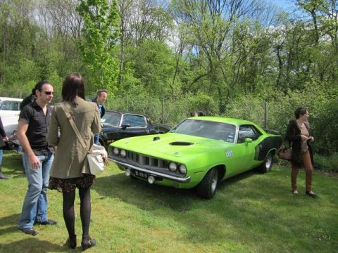 1991 Ford LTD Crown Victoria - A bright green Plymouth Barracuda is the focus of this outdoor gathering, with several people observing the classic car.