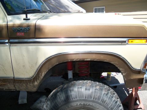 1979 Ford Bronco - Close-up of a 1979 Ford Bronco's side fender, showing the 'Bronco Ranger XLT' badging and suspension components.