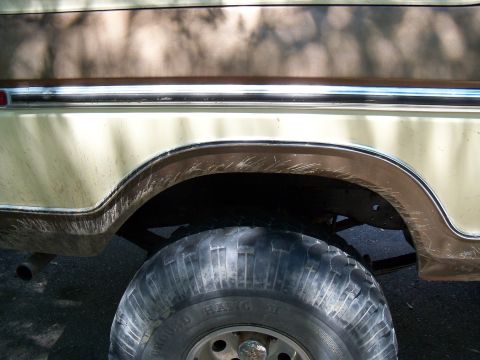 1979 Ford Bronco - Close-up of the rear wheel well on a 1979 Ford Bronco, showing its side profile and chrome accents.