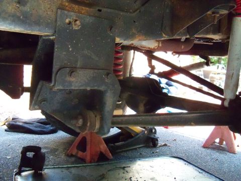 1979 Ford Bronco - Undercarriage view of vehicle suspension and frame components being worked on.