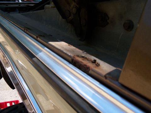 1979 Ford Bronco - The door sill shows significant rust and wear, with a chrome trim piece running along the bottom edge.