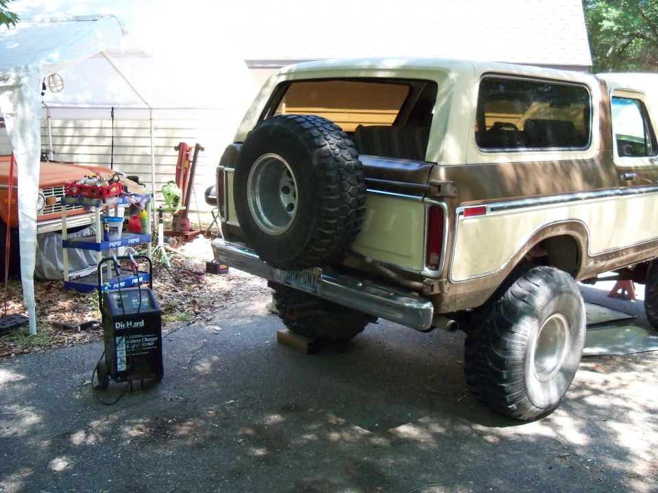 1978 Ford Bronco rear view, spare tire on tailgate, another vehicle partially visible under a tent