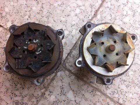 1998 Ford Crown Victoria - Comparison of a worn-out water pump next to a new one, both with visible impellers.