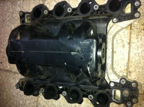 1998 Ford Crown Victoria - A black plastic intake manifold with a metal bracket is shown. The Ford logo is visible on the bracket.