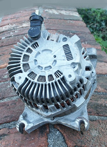 1998 Ford Crown Victoria - Close-up of an automotive alternator, with a website logo visible.