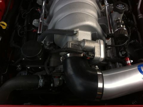 2010 Dodge Challenger - Close-up view of an engine bay, showing various components and an aftermarket intake system.