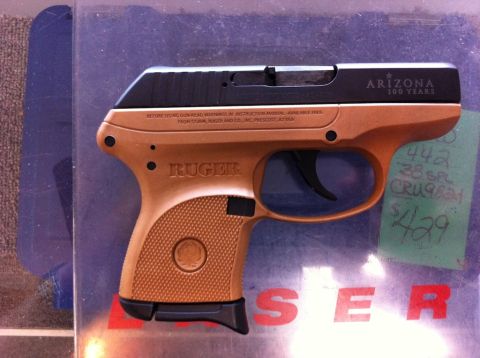 1987 Suzuki Samurai - A tan and black Ruger pistol is displayed, with text indicating "ARIZONA 100 YEARS" and "RUGER".