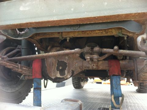 1986 Ford Bronco - Close-up view of the front axle and suspension components of a truck.