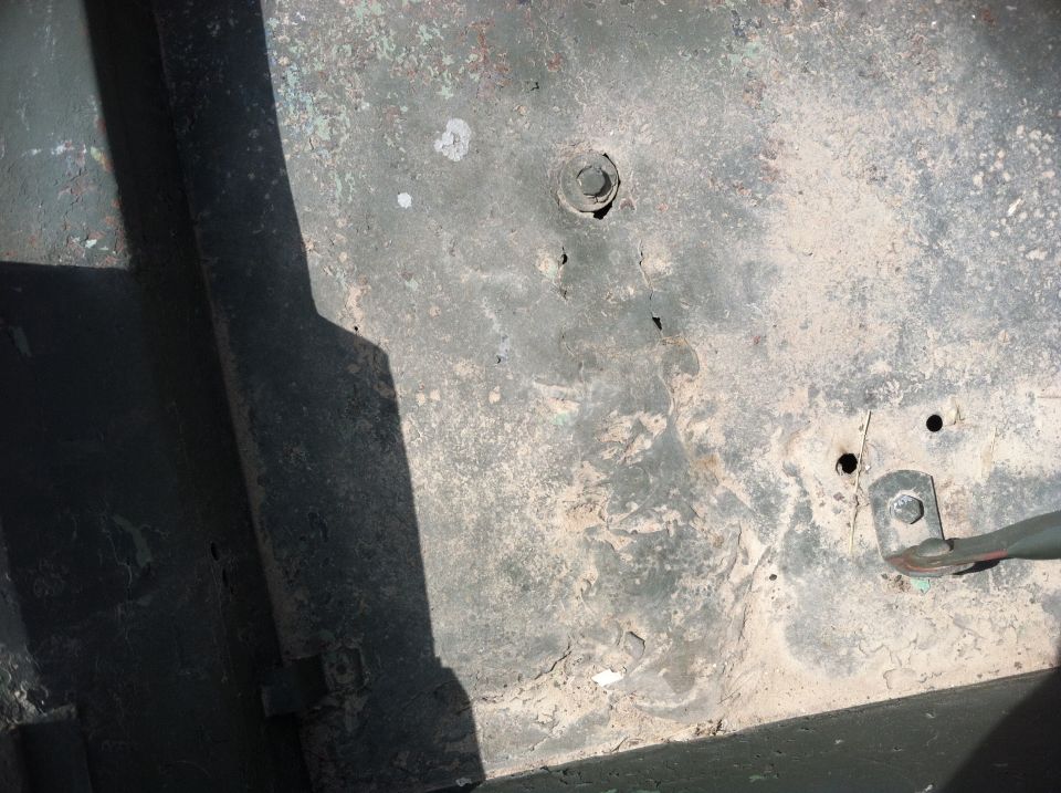 Underbody of a vehicle with rust and a bolt