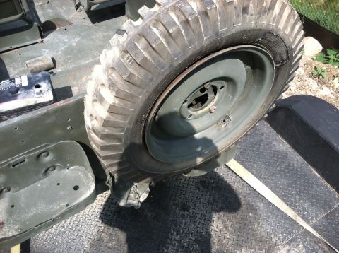 1986 Ford Bronco - Close-up of a spare tire and fender on a military vehicle, possibly being transported.