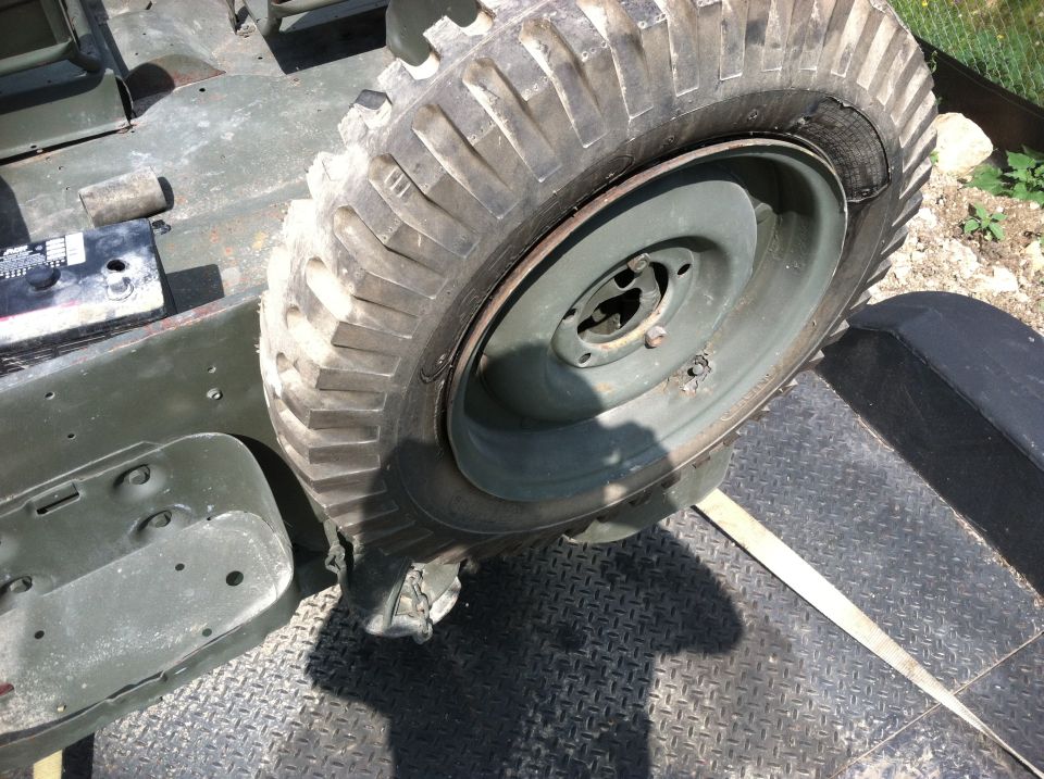 Spare tire mounted on a military vehicle's fender, showing part of the chassis