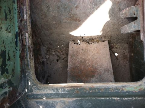 1986 Ford Bronco - The interior of the vehicle shows significant rust and wear, with debris scattered on the floor.