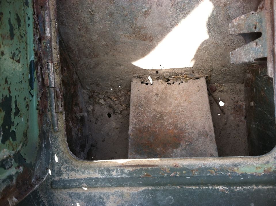 inside of a rusty vehicle, looks like the cargo area or undercarriage