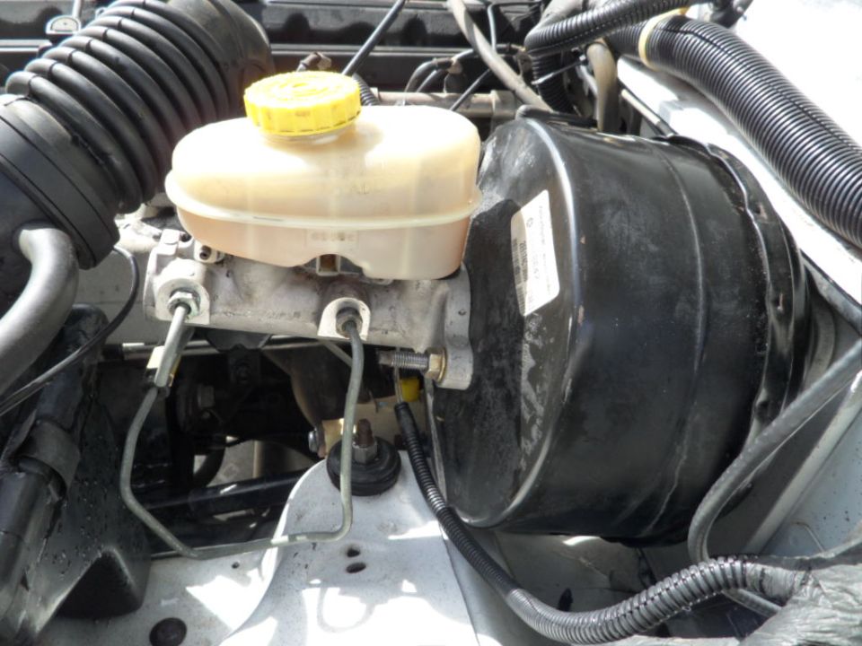 Brake booster and master cylinder assembly with yellow cap on reservoir