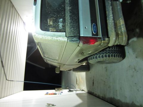 1992 Ford Bronco - Rear view of a muddy 1992 Ford Bronco parked indoors.