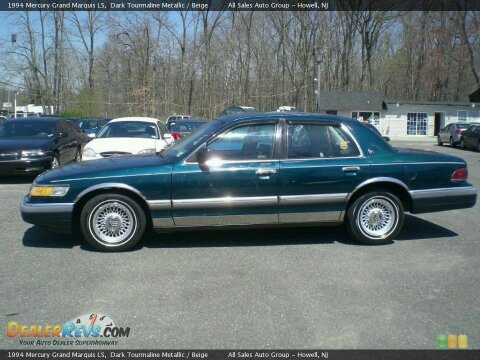 1994 Mercury Grand Marquis - A 1994 Mercury Grand Marquis LS sedan is parked in a lot with other vehicles and buildings in the background.