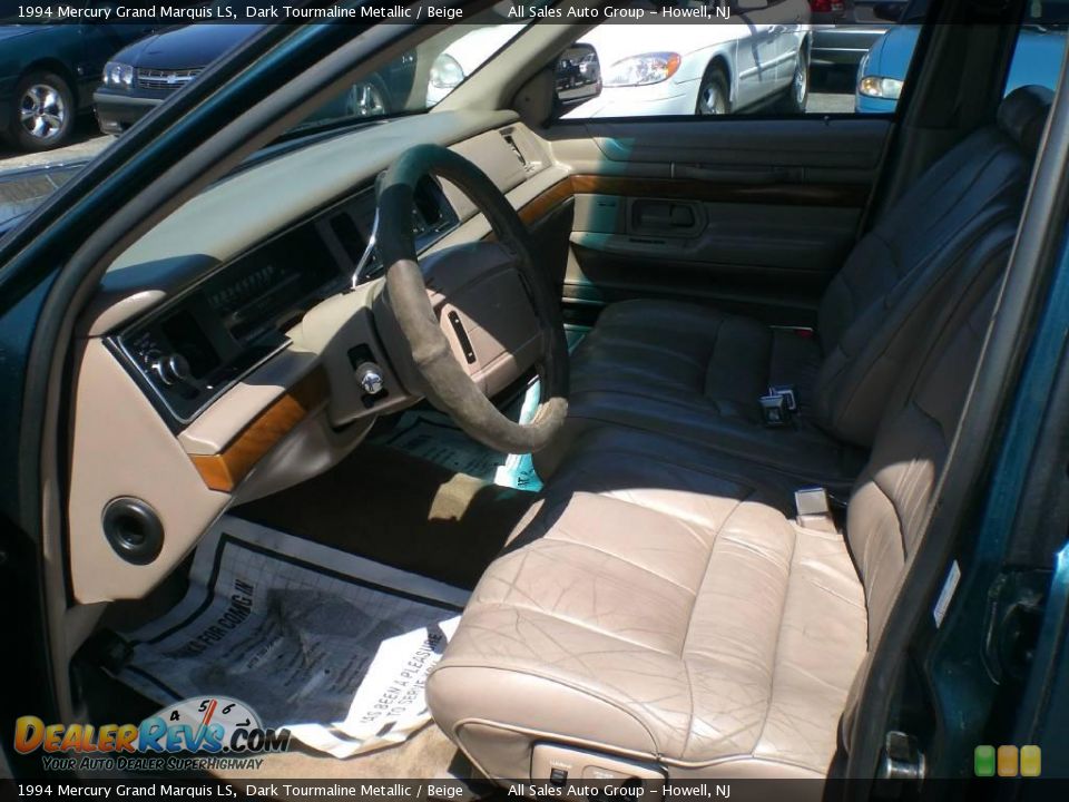 Beige leather interior and dash of a 1994 Mercury Grand Marquis seen through the driver's door