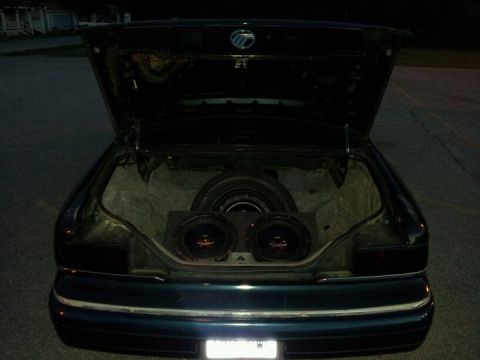 1994 Mercury Grand Marquis - Rear view of a 1994 Mercury Grand Marquis showing the trunk with a spare tire and aftermarket subwoofers installed.