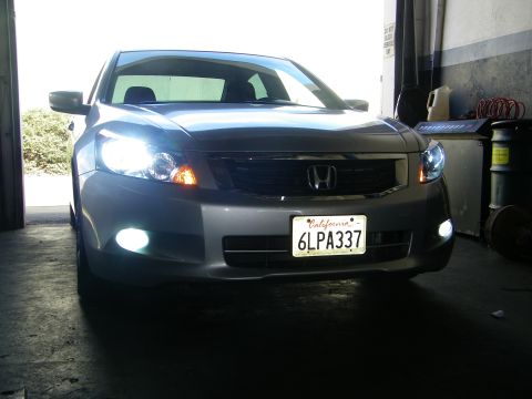 2010 Honda Accord - Front view of a 2010 Honda Accord sedan, showing its headlights and fog lights illuminated.