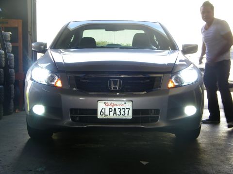 2010 Honda Accord - This silver Honda Accord features its headlights and fog lights illuminated, with a person standing nearby.