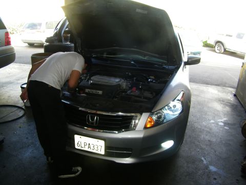 2010 Honda Accord - A person works on the engine of a silver Honda Accord, which appears to be a 2008 model year.
