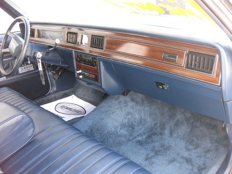 Interior of a 1985 Ford Crown Victoria LTD showing the dashboard and blue seats